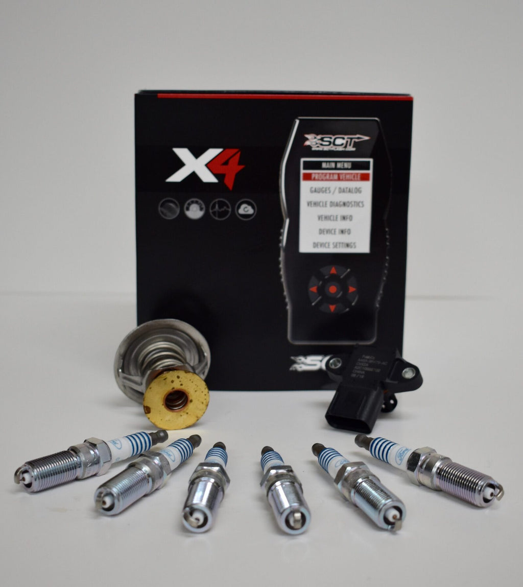 A set of new spark plugs and an electronic device.