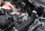 A person is working on the engine of an automobile.
