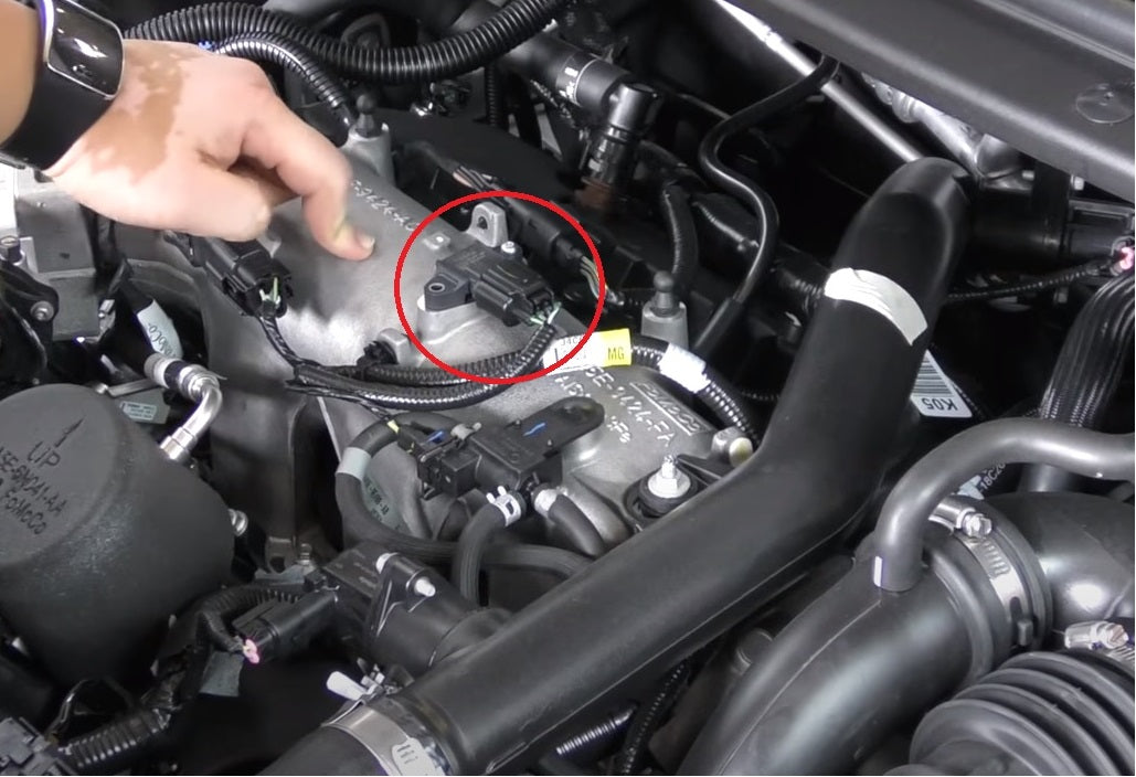 A person is working on the engine of an automobile.