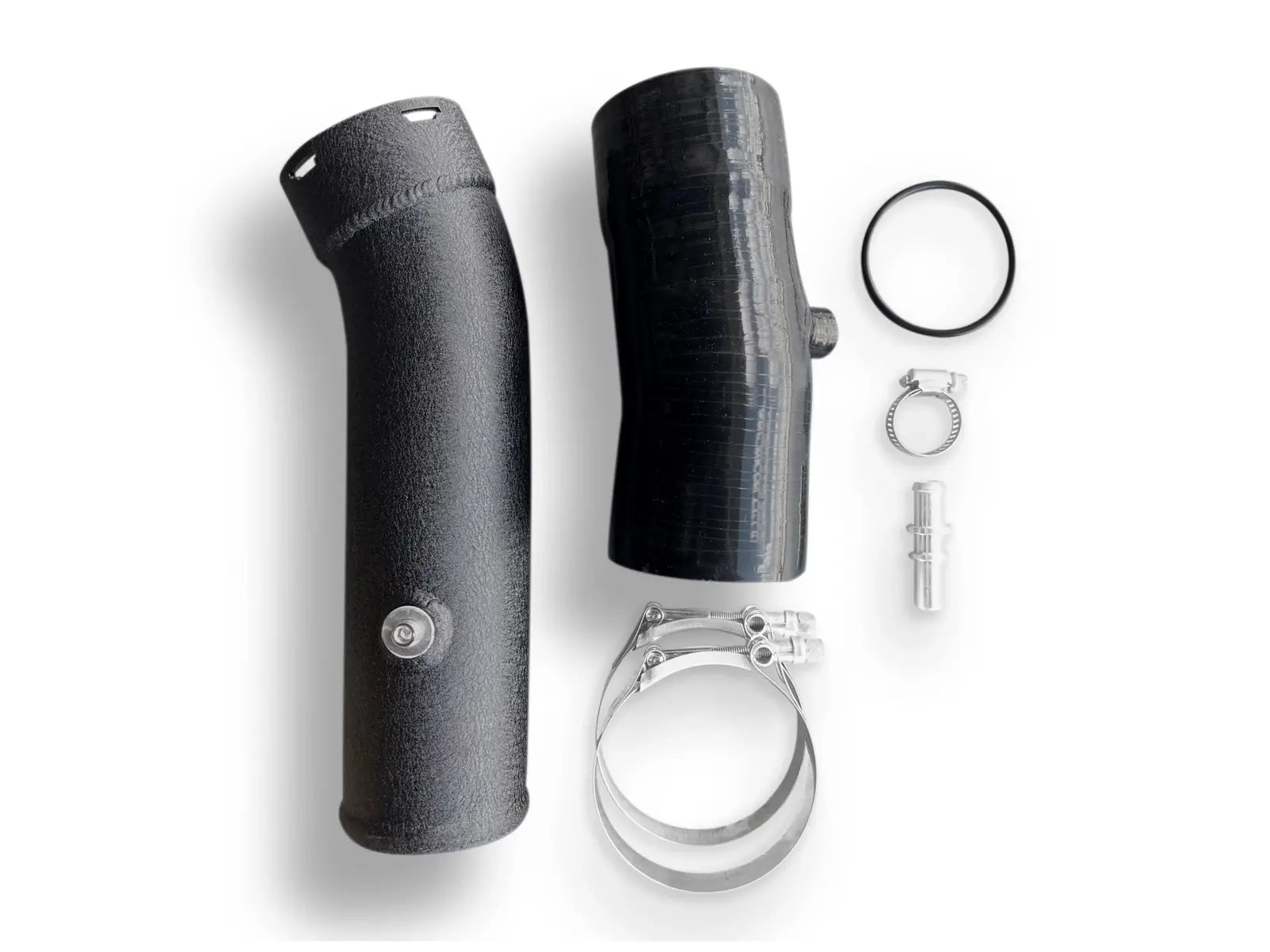 A black pipe and its parts are laying on the ground.