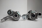 Two turbochargers are sitting on a table.